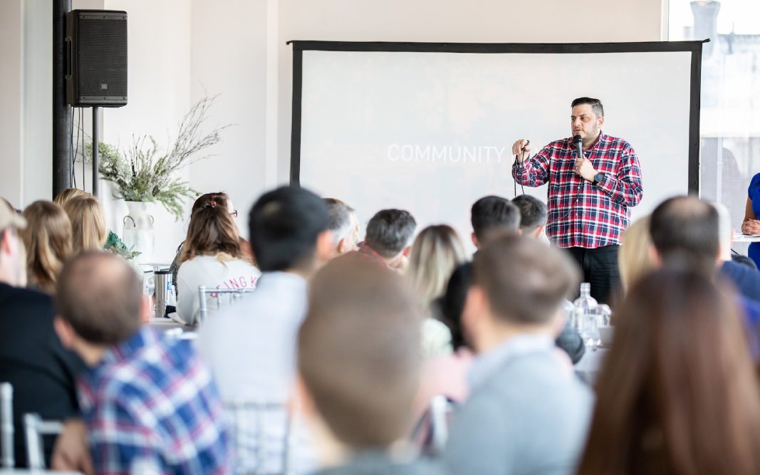 Nick Lenzi holding a microphone, training church leaders with audience in the foreground