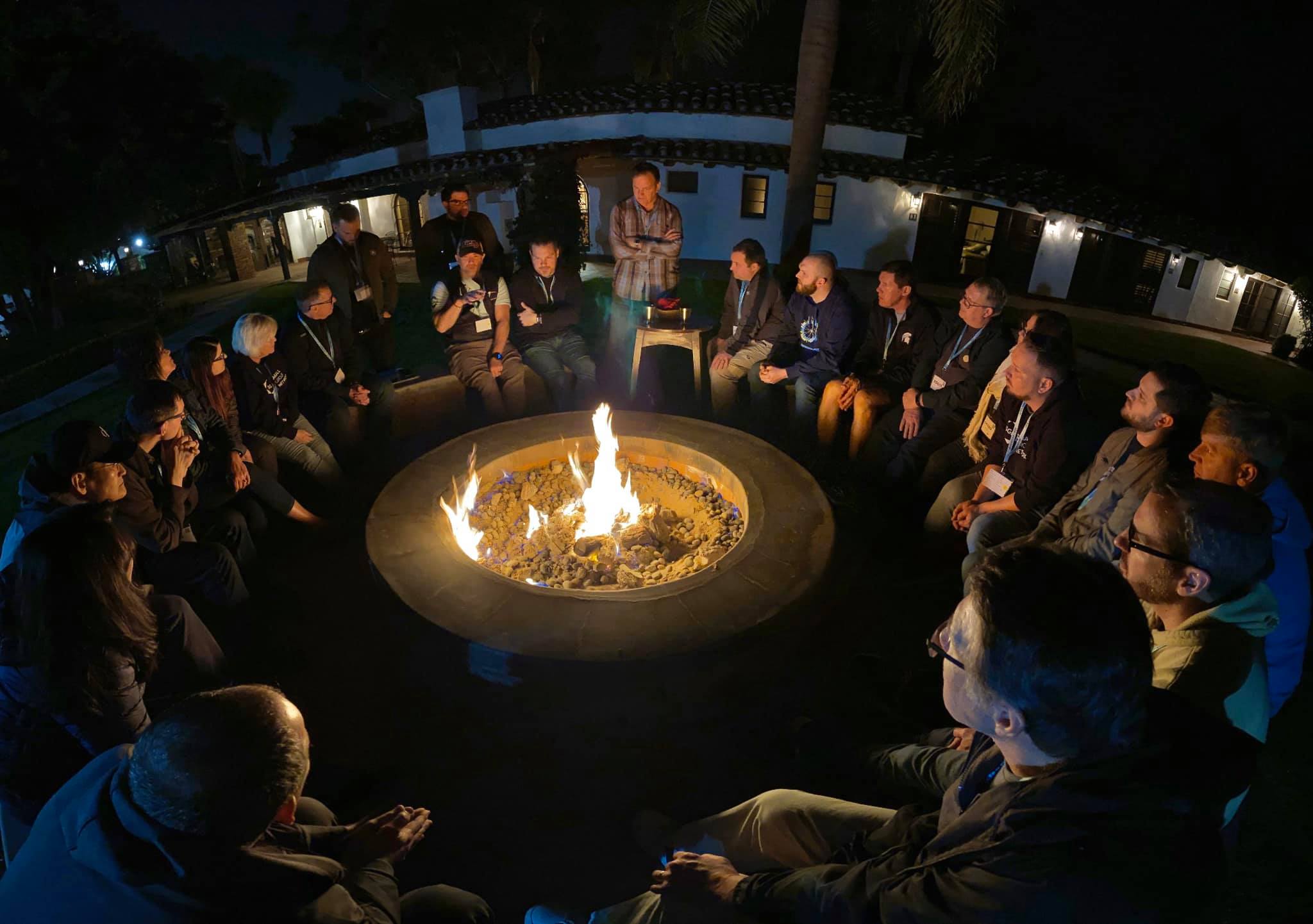 Small group gathered around a campfire for a nighttime discussion and fellowship